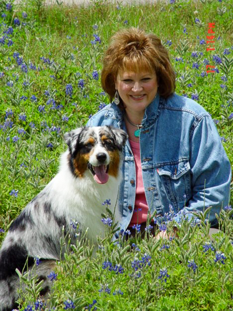 A past photo of Martha in her denim jacket on a sunny field of blue flowers next to her beloved dog companion evokes a sense of nostalgia and joy.