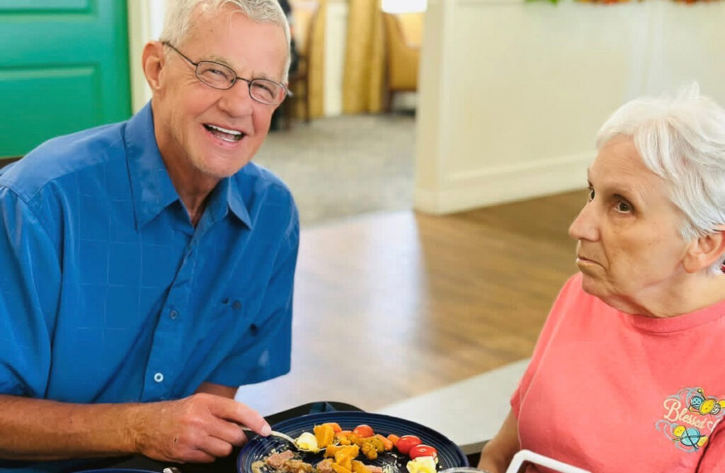 A senior man and woman enjoy a meal at The Castlewood Senior Living.